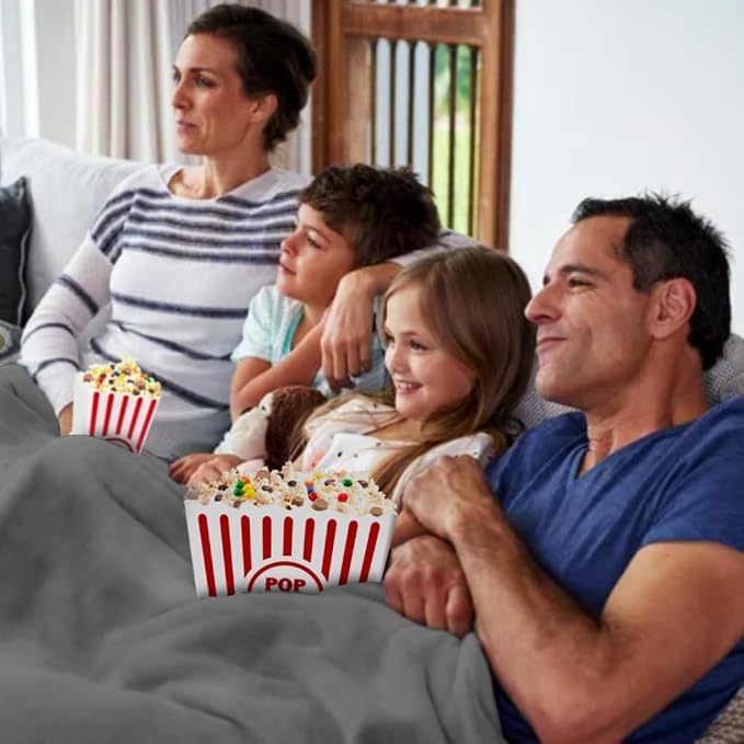 Family relaxing together during movie night with popcorn and a cozy fleece blanket
