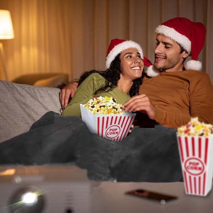 Couple enjoying movie night with popcorn and fleece blanket during the holidays