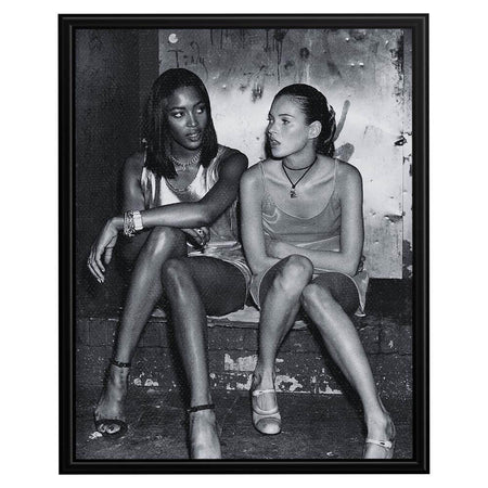 Wownic fashion icon poster featuring two models seated together in a candid black-and-white editorial portrait