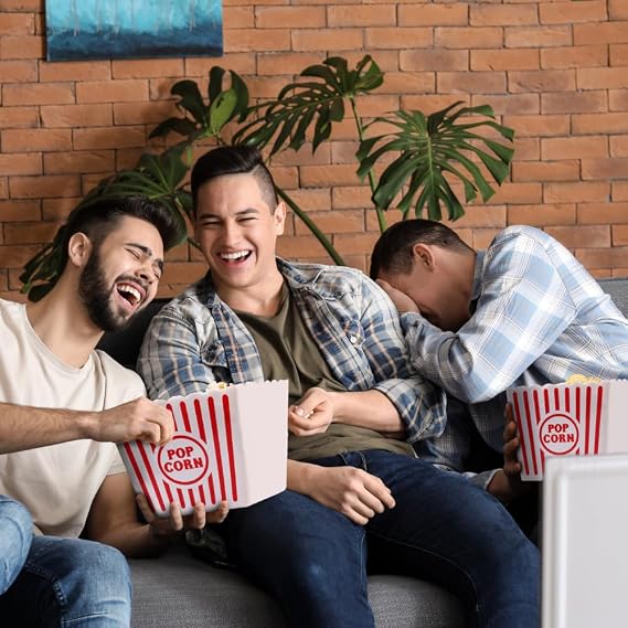 Friends enjoying snacks from large popcorn buckets during movie night